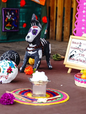 Ofrenda con calavera decorata e figure tradizionali durante il Día de los Muertos Roma 2024.