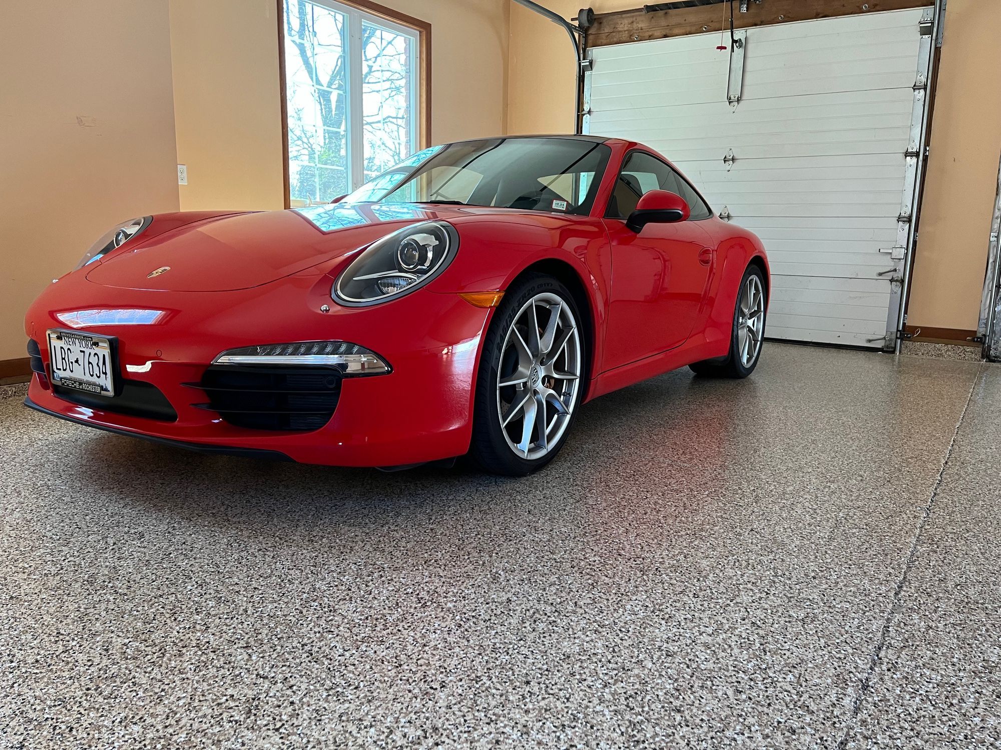 Red sports car parked on epoxy coated garage floor