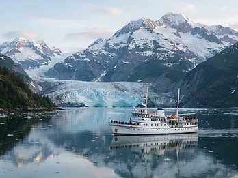 Expedition cruise ship in a glacier-lined Alaskan fjord