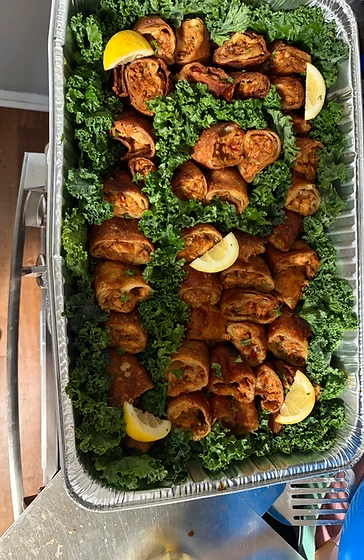Crispy fried egg rolls with lemon on a bed of kale