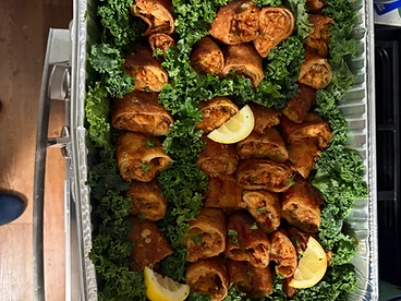 Crispy fried egg rolls with lemon on a bed of kale