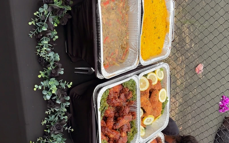 Overhead view of a Pleasurable Plates catering spread on a black tablecloth