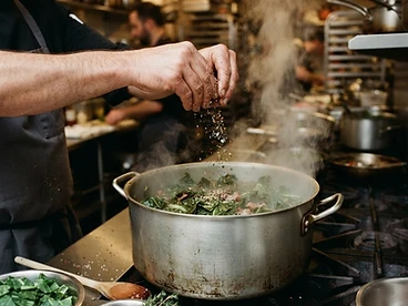 Seasoning a steaming pot of collard greens
