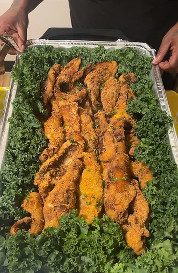 Hands holding a catering tray of golden fried fish