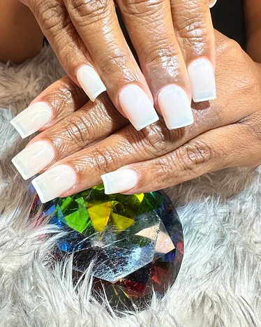 Long square nails in a glossy milky-white finish posed on a crystal