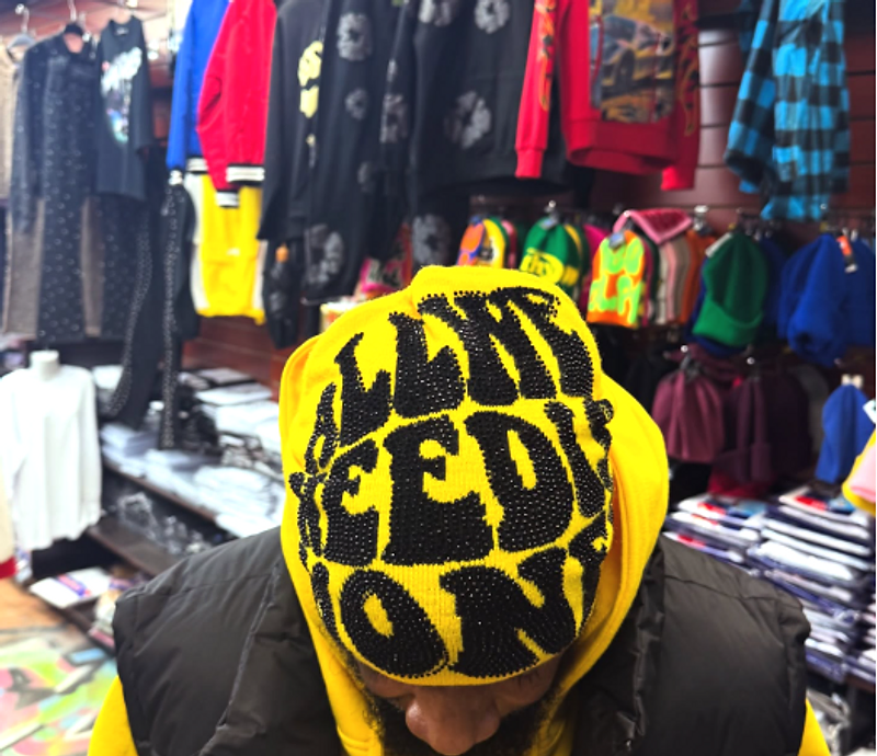 Customer wearing a yellow hoodie and graphic beanie in the store