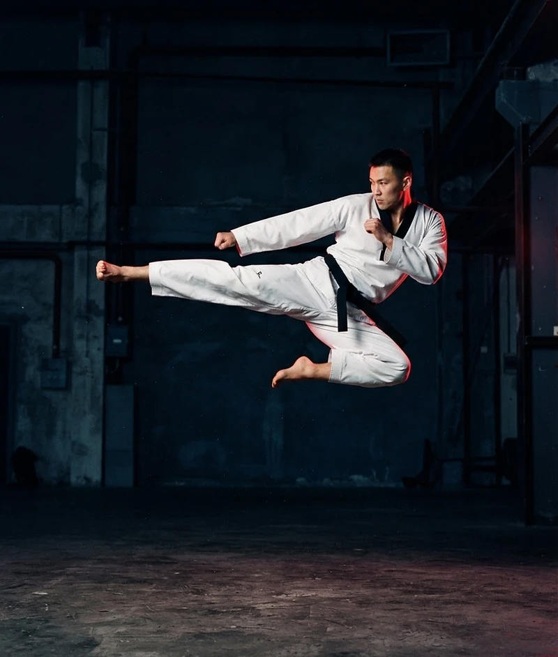Black belt executing a flying side kick