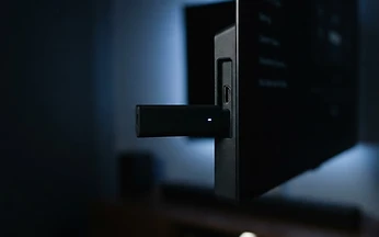 Streaming stick plugged into the HDMI port of a television, illustrating IPTV installation on Fire TV in the UK