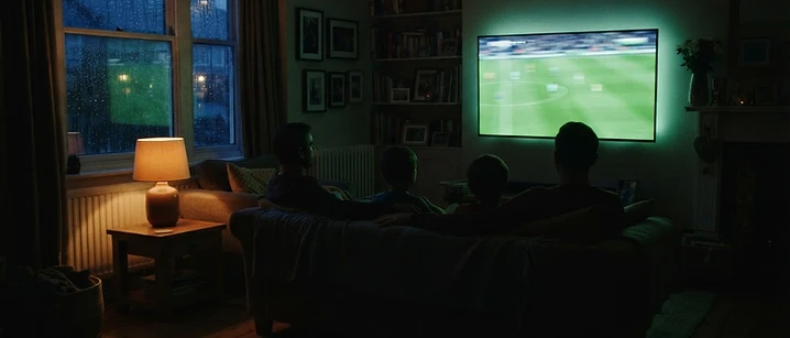 British living room in the evening with a large television glowing
