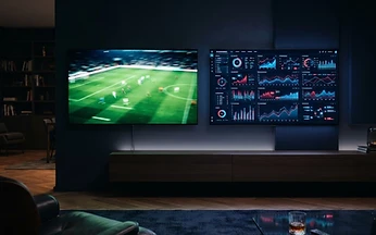 Two televisions side by side, one showing a live sports broadcast and the other showing performance graphs, used to compare IPTV providers in the UK