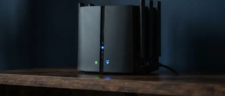 Wi-Fi router with glowing status lights on a shelf, illustrating IPTV buffering causes and router fixes in the UK