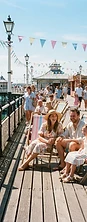 Sunlit British seaside pier with colourful deckchairs