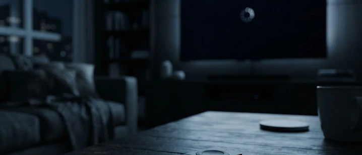 Dim living room with a television showing a loading spinner and a remote control in the foreground