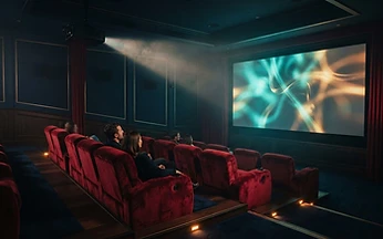 Cinematic dark room with warm ambient lighting and a television screen glowing in the background