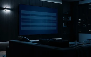 Television in a dark living room showing an empty blue grid layout resembling a blank schedule