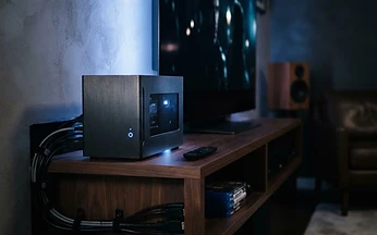 Small home media computer on a shelf beside a television, illustrating IPTV setup on Kodi in the UK