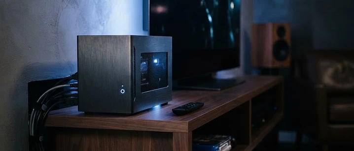 Small home media computer on a shelf beside a television, illustrating IPTV setup on Kodi in the UK