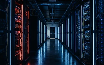 Illuminated server racks in a data centre corridor with one highlighted rack, illustrating UK based IPTV server infrastructure