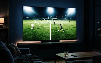 Television showing a floodlit sports pitch in a dark living room, illustrating IPTV sports streaming quality checks in the UK