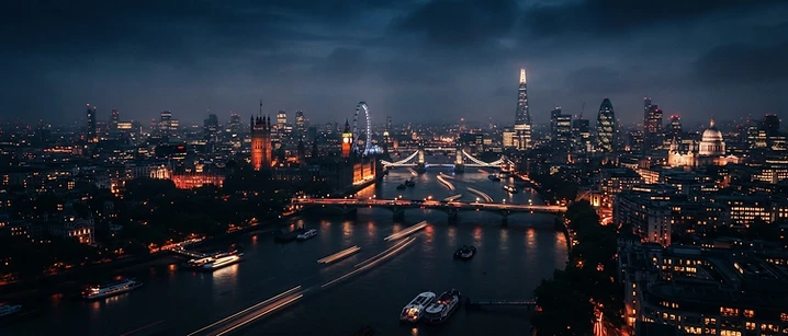 London skyline at dusk with lit windows reflected in the River Thames