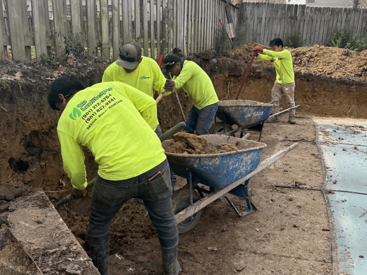 901 Lawnscape crew hand-digging and hauling dirt on a backyard pool project