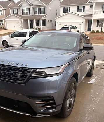 Mobile car detailing on a light grey Range Rover SUV