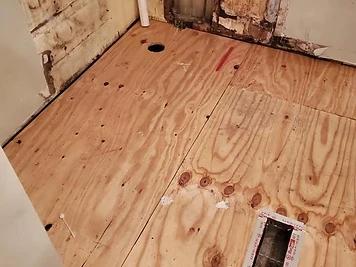 Plywood subfloor replacement with new sheets installed and secured before flooring