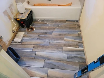 Completed bathroom floor tile installation with a coordinated tile pattern