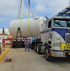 Tanque blanco izado por grúa sobre Freightliner