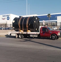 Tanque negro sobre camión rojo