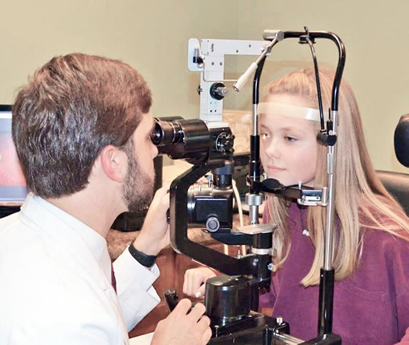 Optometrist giving an eye exam in a modern clinic
