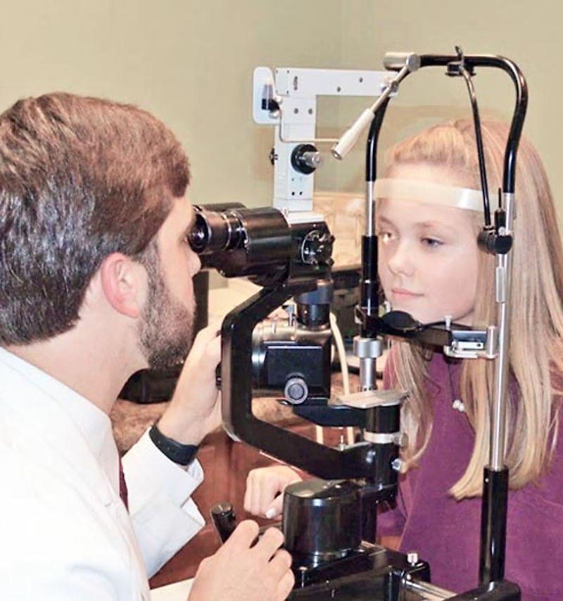 Optometrist website design: optometrist examining a patient's eyes