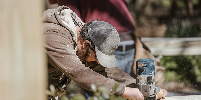 Handyman holding a phone in front of a client's home