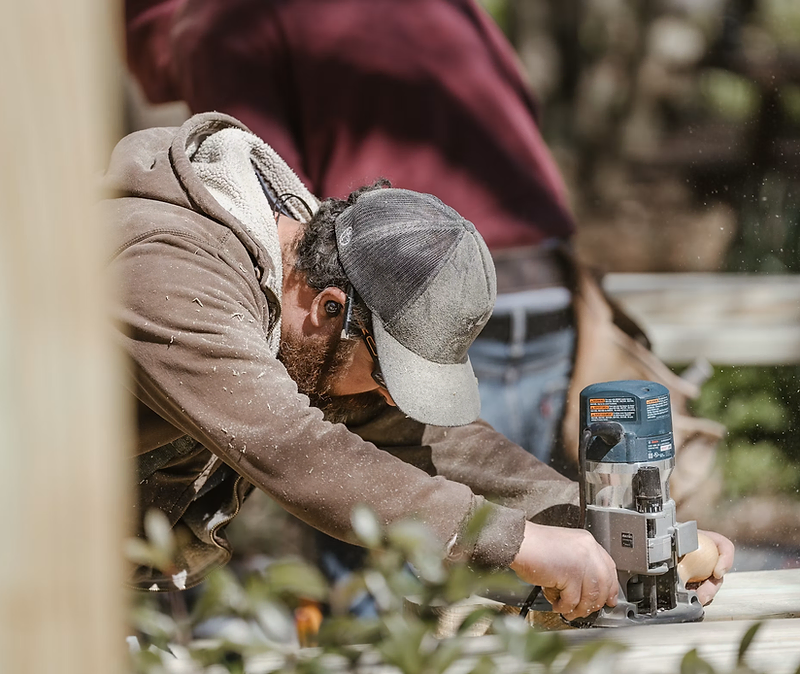 Handyman holding a phone in front of a client's home