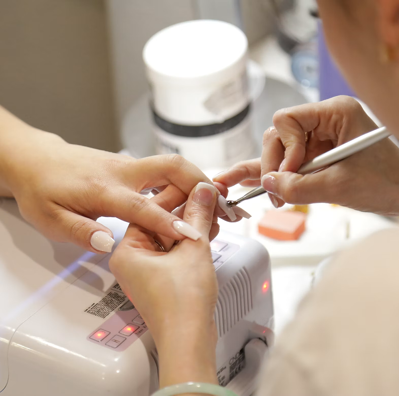 Nail salon website design: nail technician doing a manicure