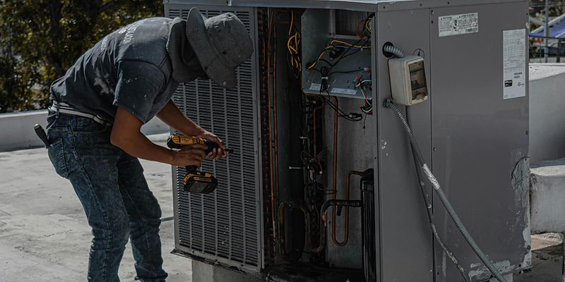 HVAC technician servicing an outdoor air conditioner