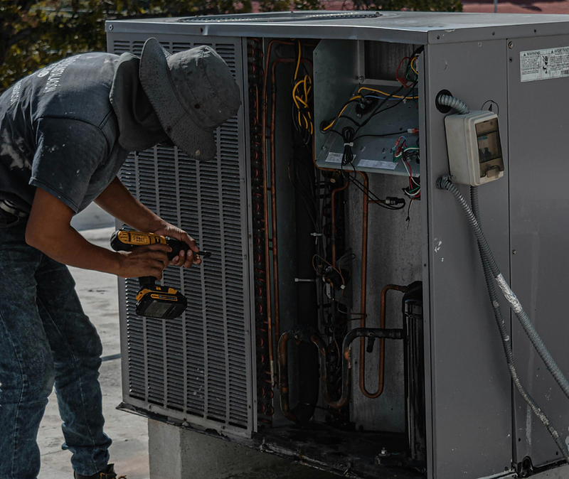 HVAC technician servicing an outdoor air conditioner