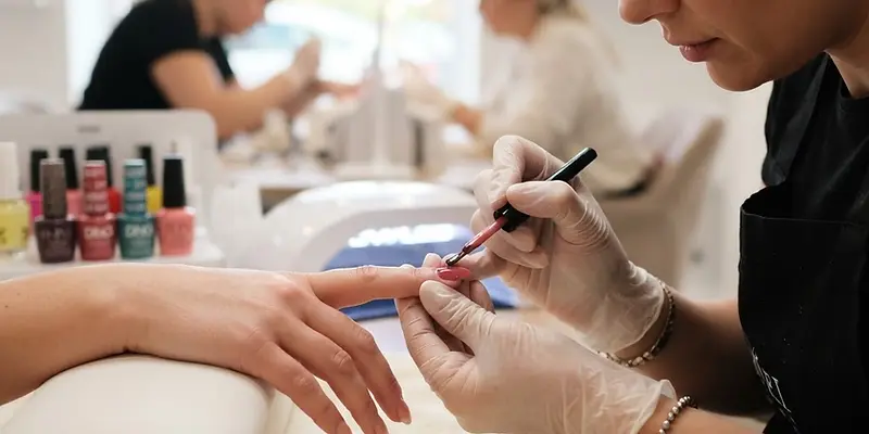 Nail technician applying gel polish in a bright nail salon