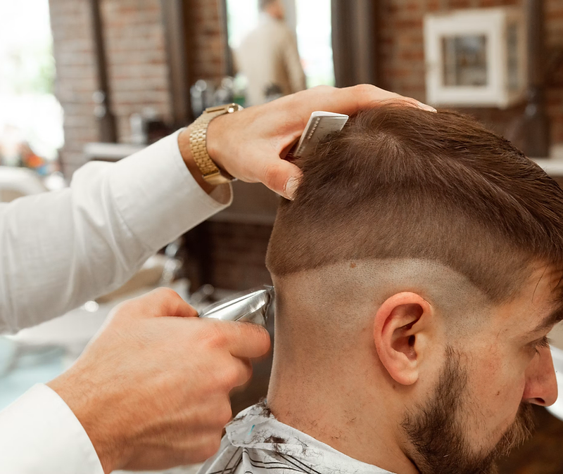 Barber giving a client a fade haircut