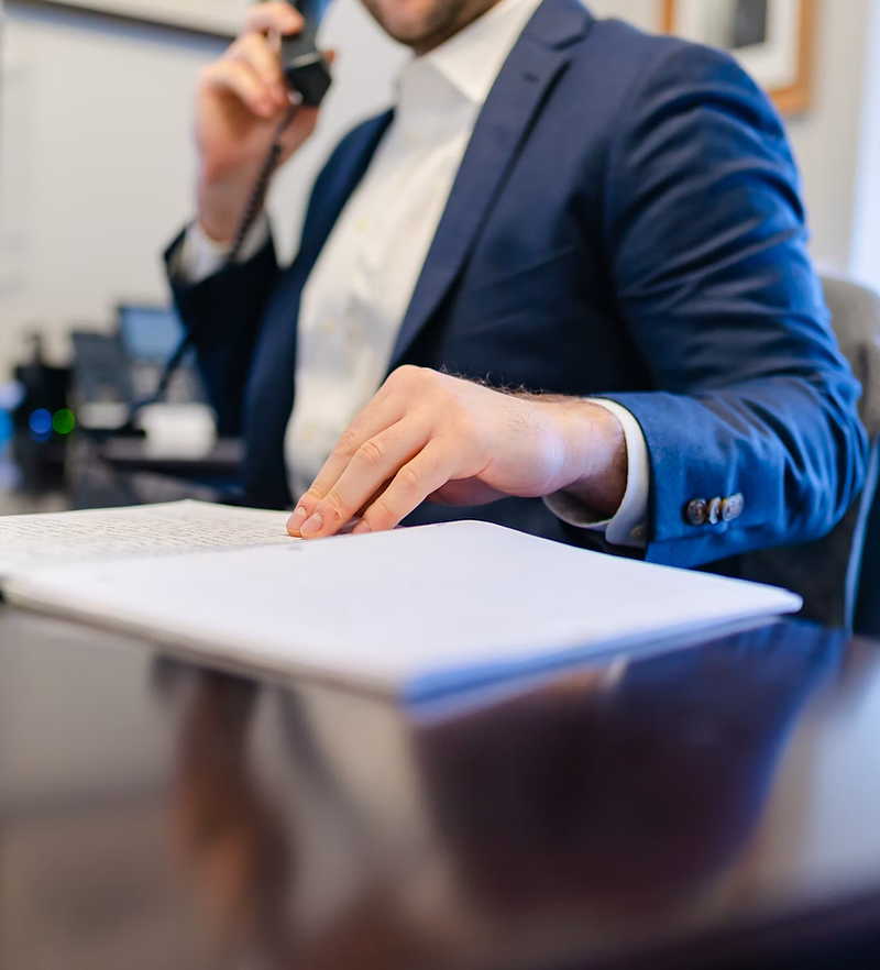 Insurance agency website design: agent on the phone reviewing a policy at his desk