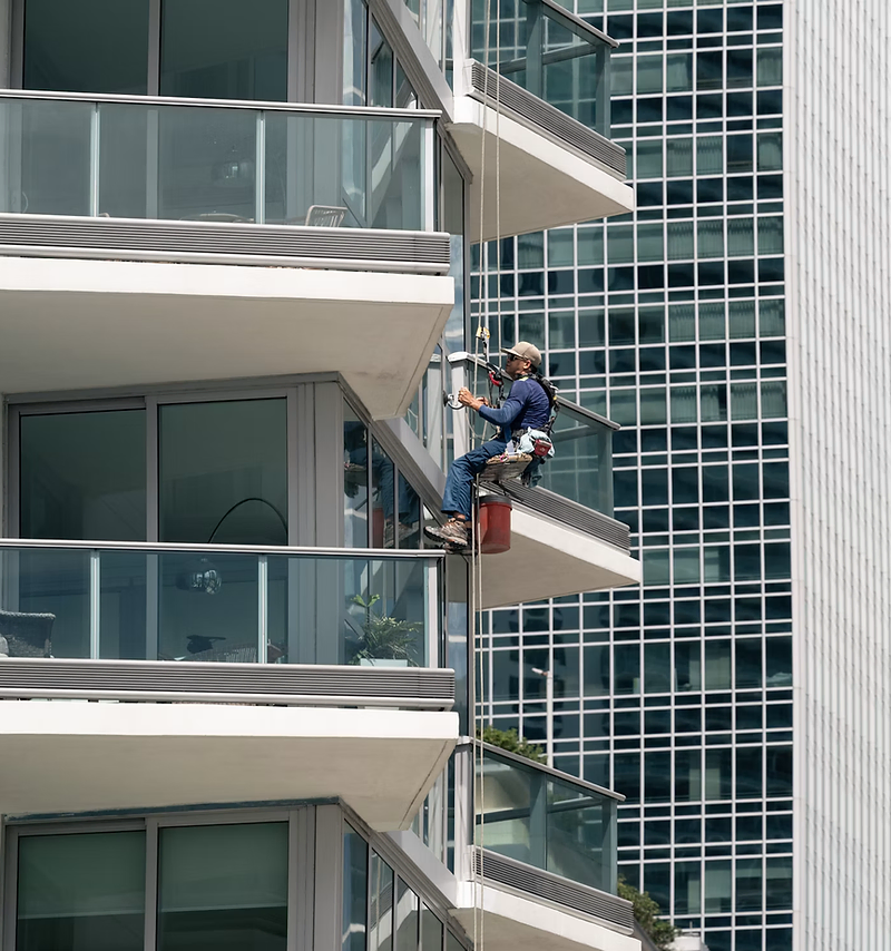Window cleaning website design: window cleaner using a squeegee on a home