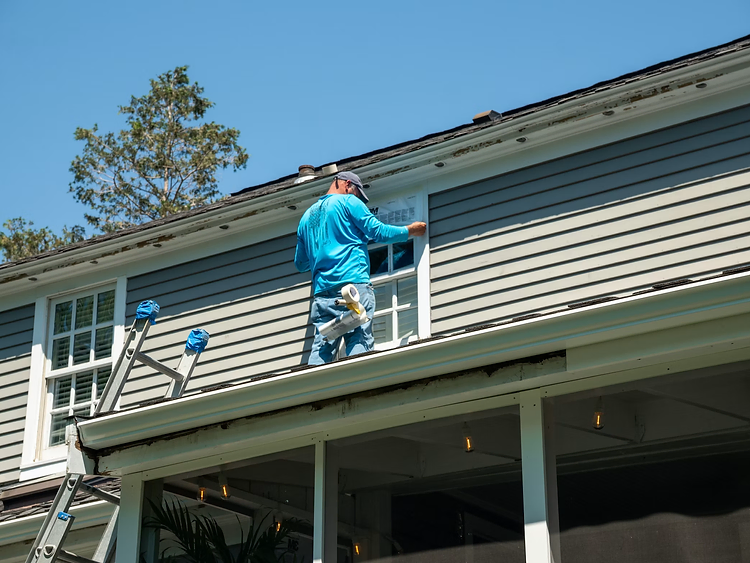 Contractor working on the upper exterior of a house