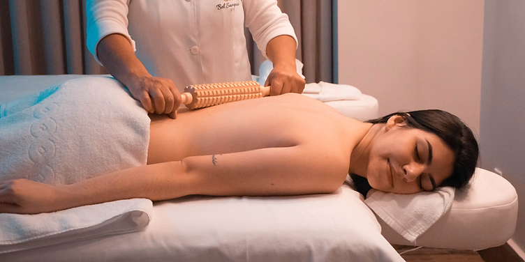 Massage therapist using a wooden roller on a client's back