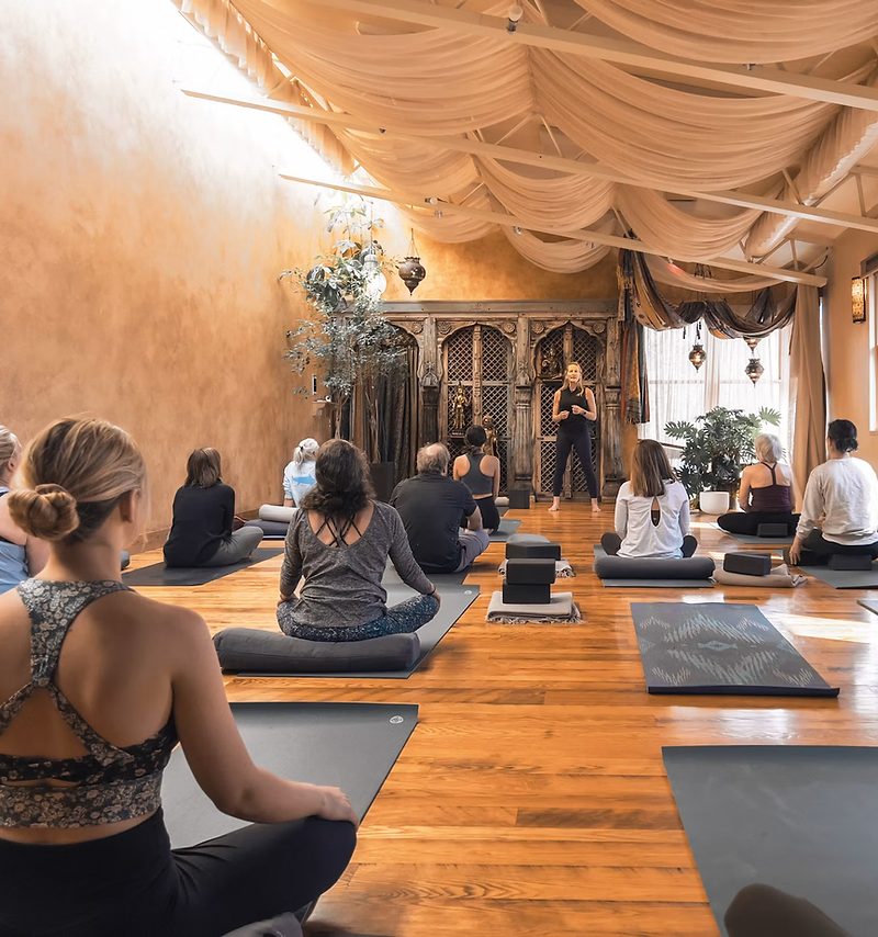 Yoga studio website design: students practicing in a bright wooden studio
