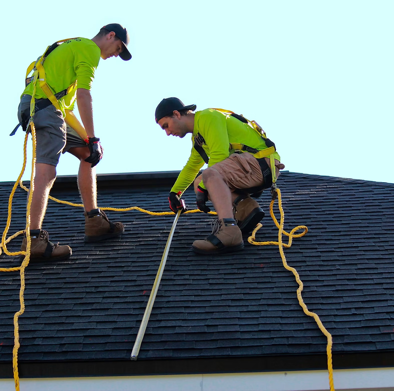 Roofing website design: roofing crew replacing shingles on a two-storey house