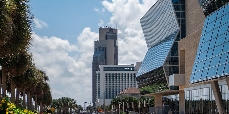 Palm-lined street in downtown Corpus Christi with glass buildings