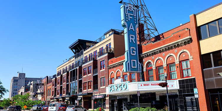 Downtown Fargo on Broadway with a historic theatre sign at dusk