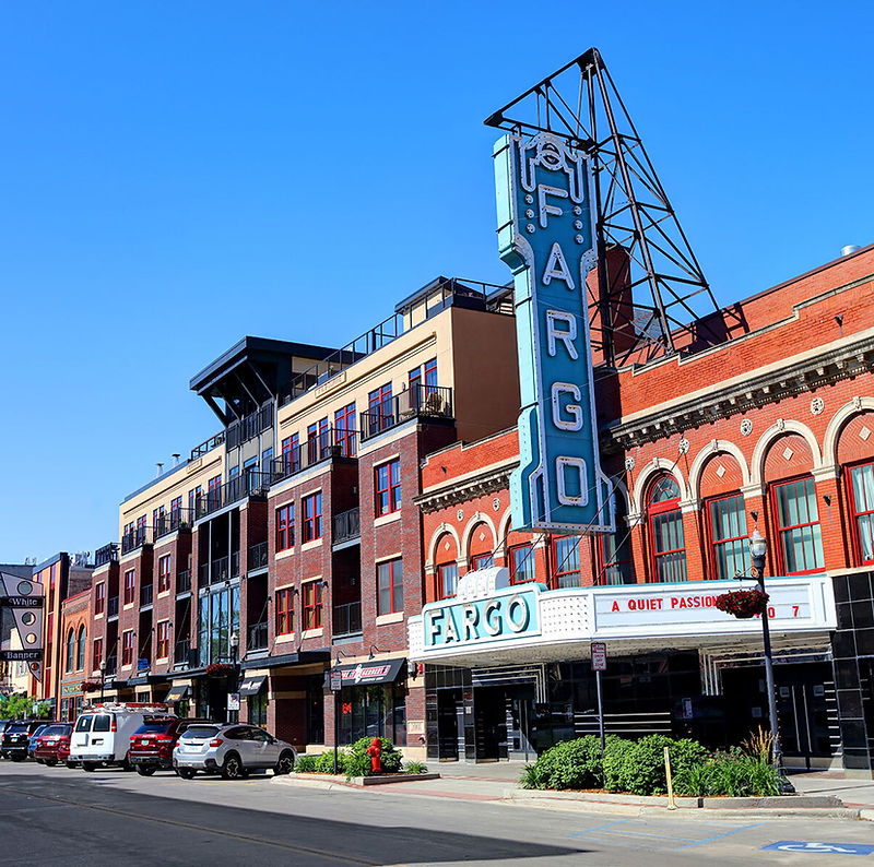 Downtown Fargo on Broadway with a historic theatre sign at dusk