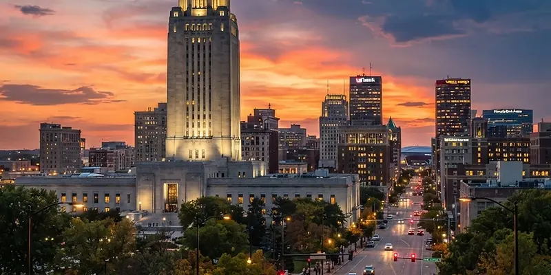 Downtown Lincoln with the Nebraska State Capitol tower at sunset