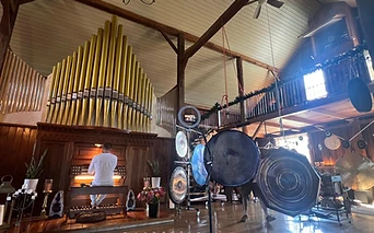 A musician at the pipe organ among the gongs
